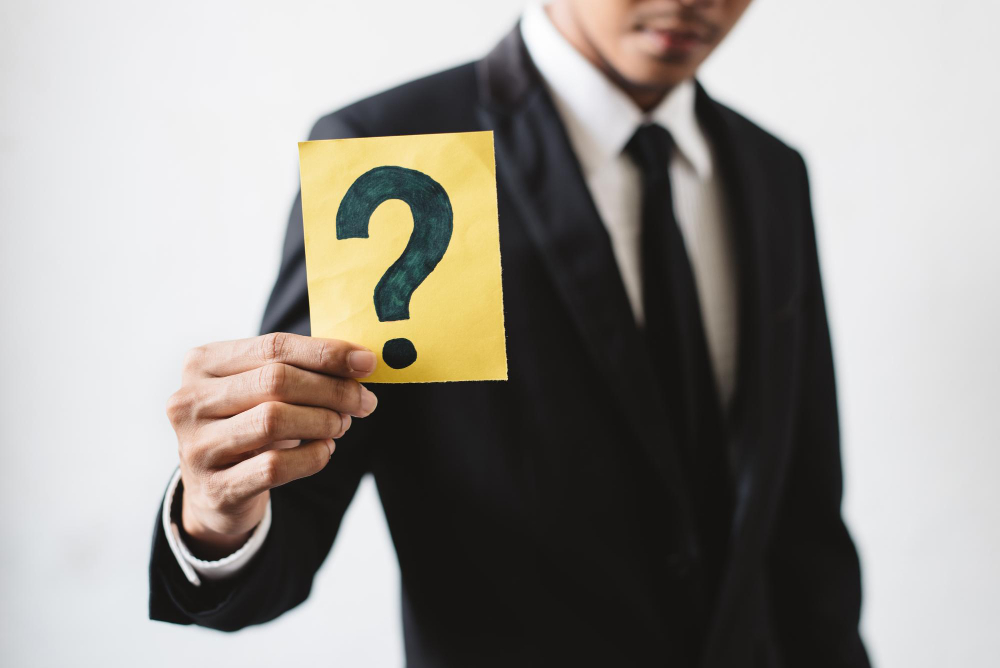 Man holding a question mark on paper