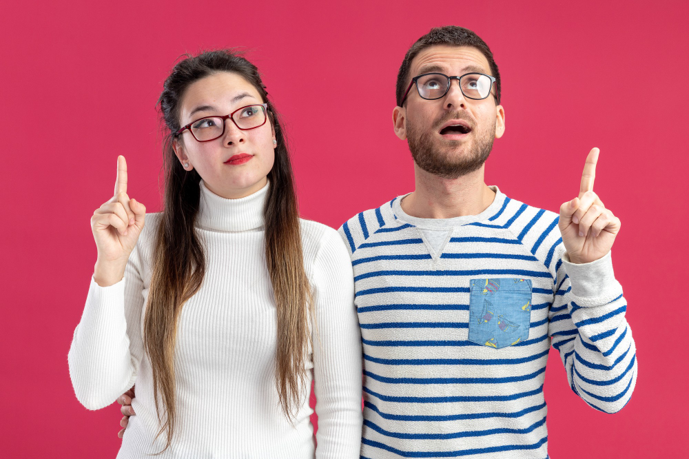 Young couple pointing confused