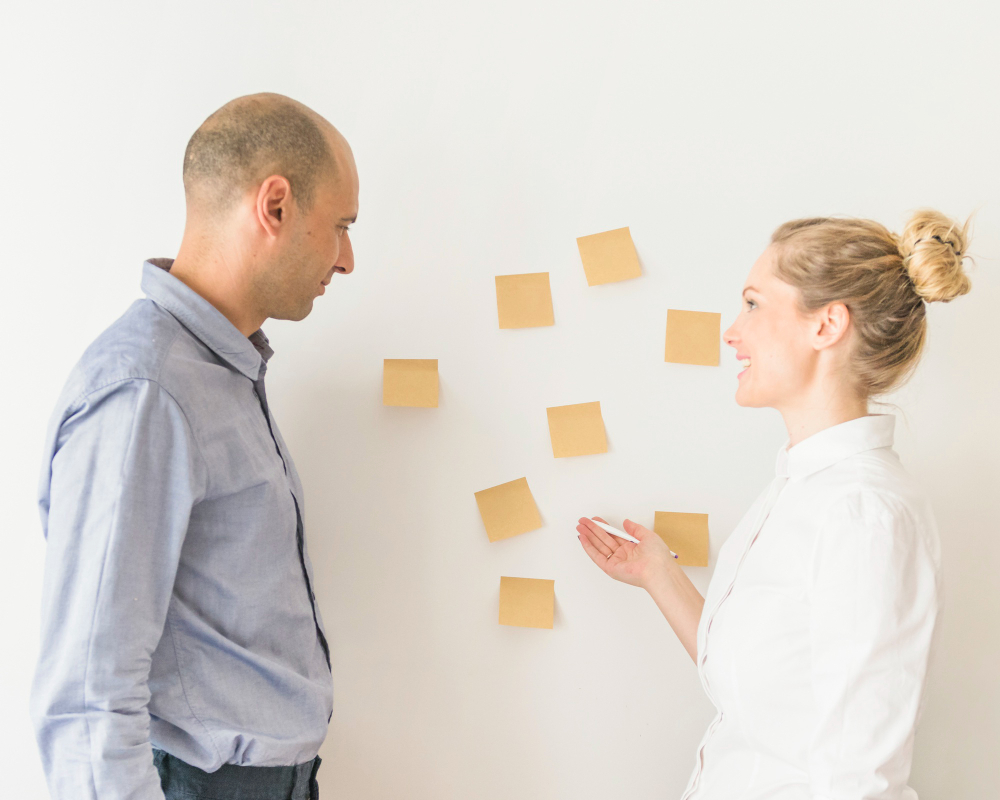 Busines speople planning with notes on a wall